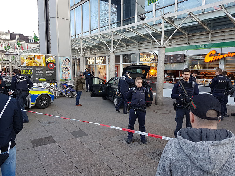 A car stands in front of a store guarded by police in Heidelberg Germany