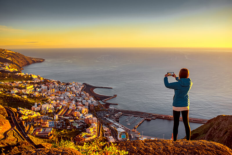 Woman taking photo of Santa Cruz on smartphone