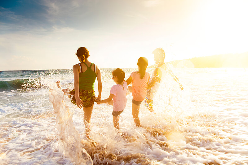 family on the beach splashing in the waves