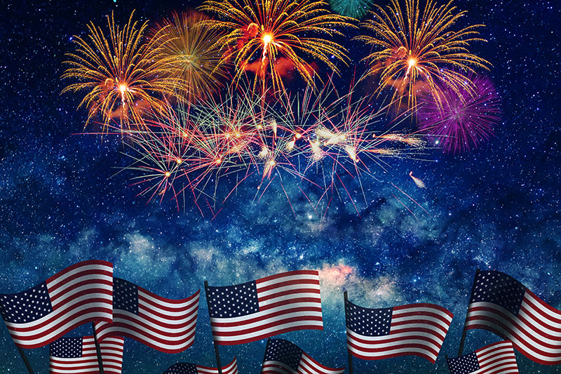 American flags with Fourth of July fireworks overhead