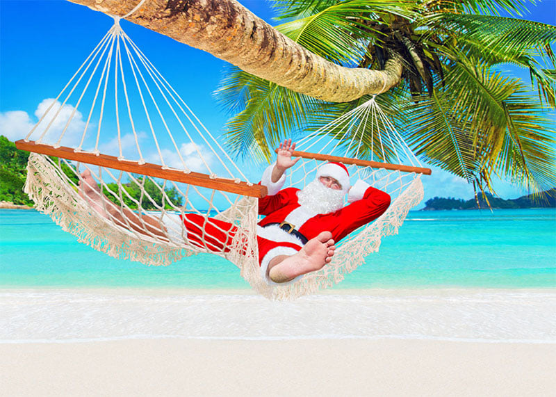 Santa lounging on a hammock on the beach