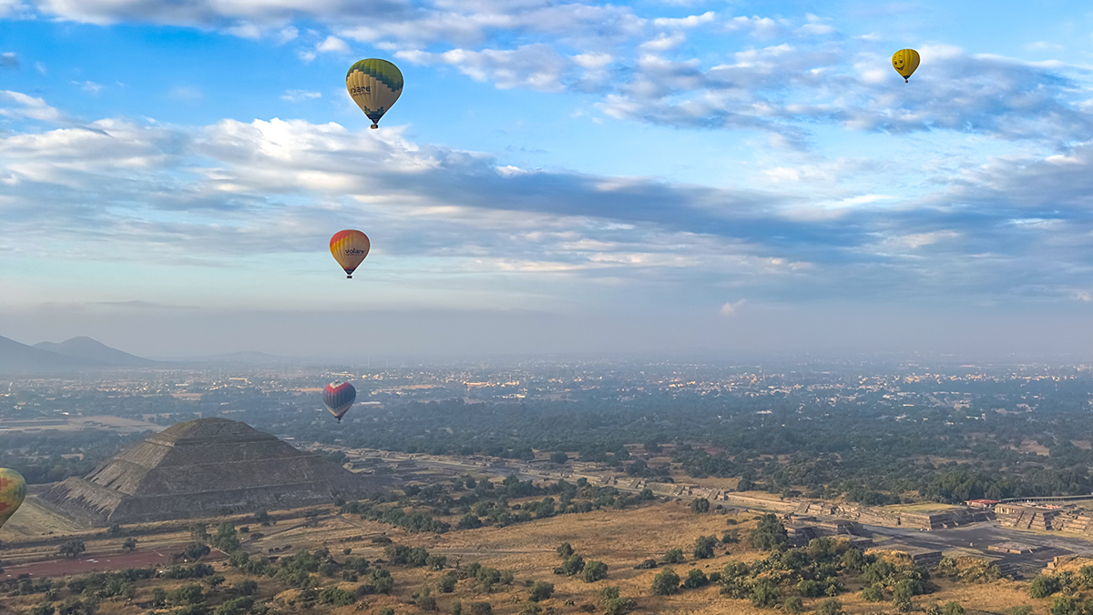 hot air balloons over Mexican archeological site