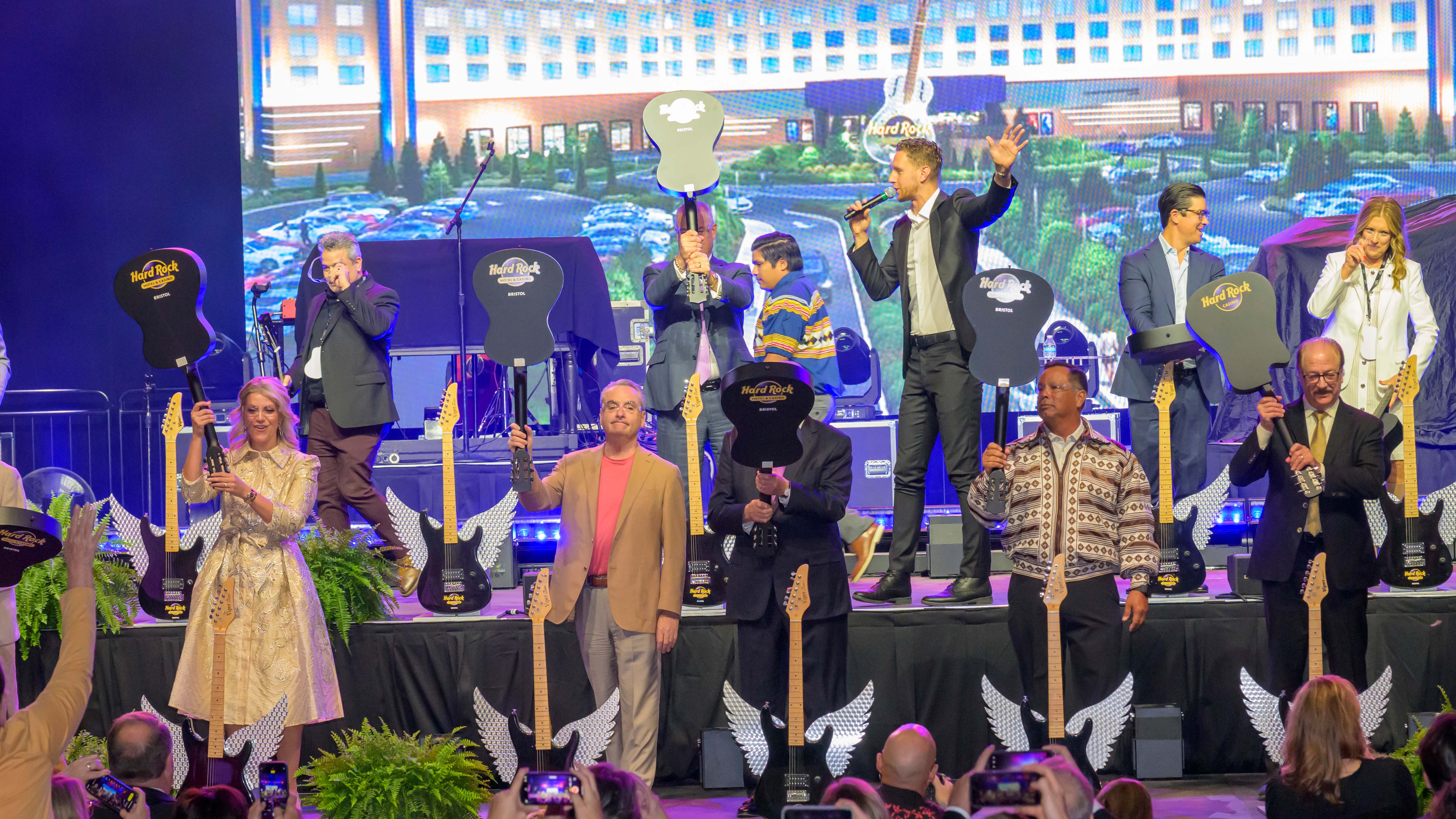 Participants in the guitar-smashing ceremony celebrate the opening of the hotel