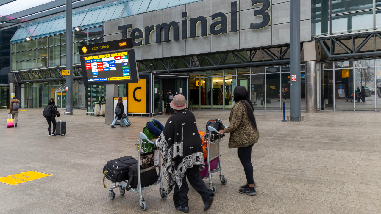 Passengers with luggage outside Terminal 3 building London Heathrow Airport