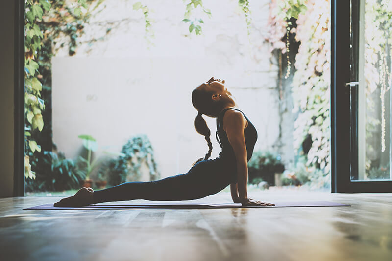 yoga instructor stretching in front of a garden