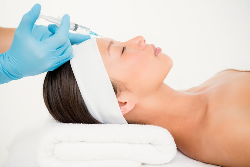 Woman receiving Botox injection on her forehead