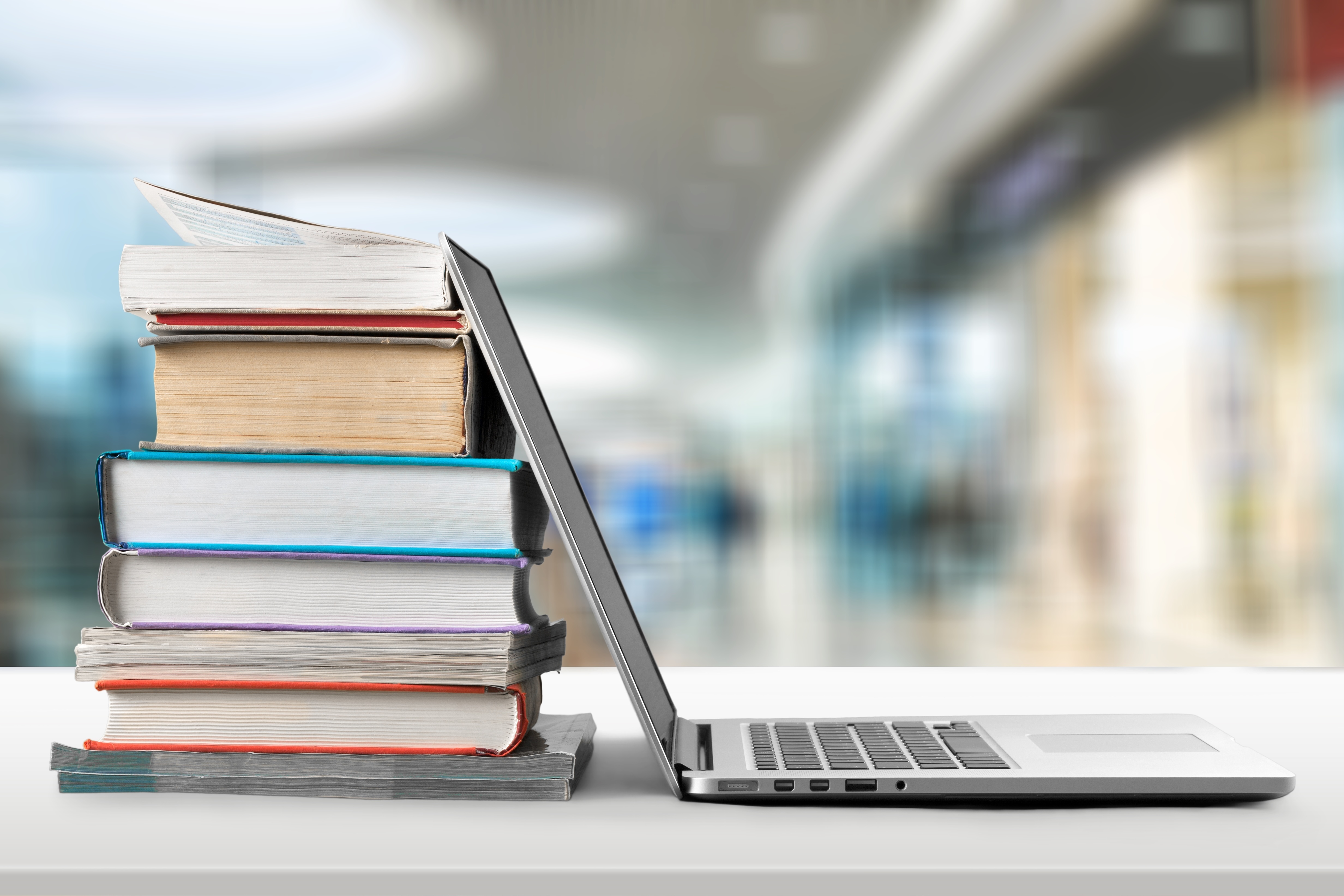 Pile of books with laptop
