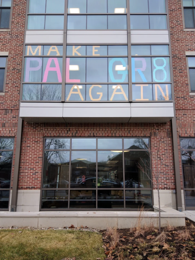Sign in a campus building window reading MAKE PAL GR8 AGAIN. One big letter appears in each pane of the window.
