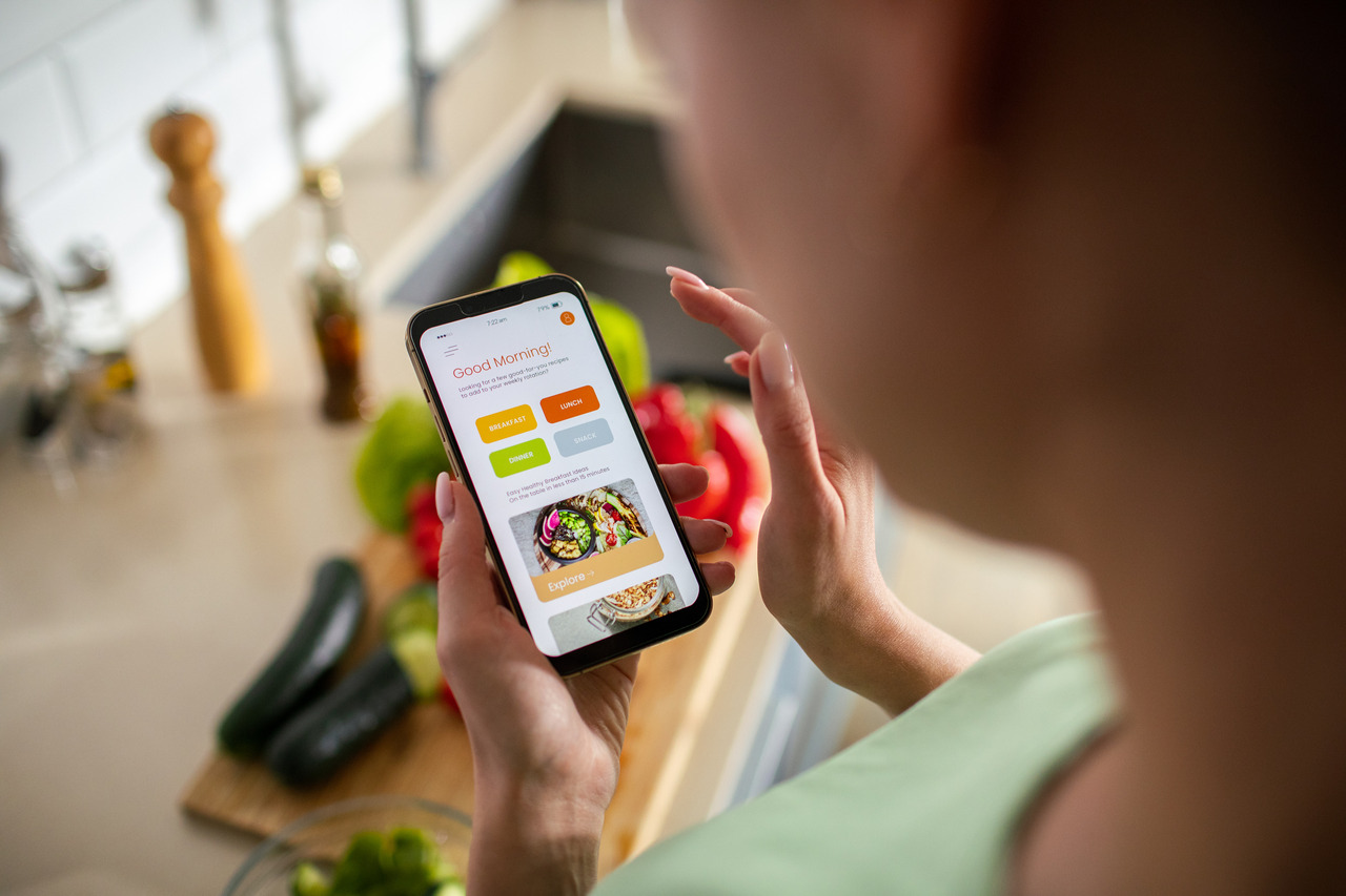 woman using weight loss app while preparing a meal