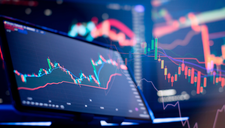 Multiple screens displaying stock tickers and financial information