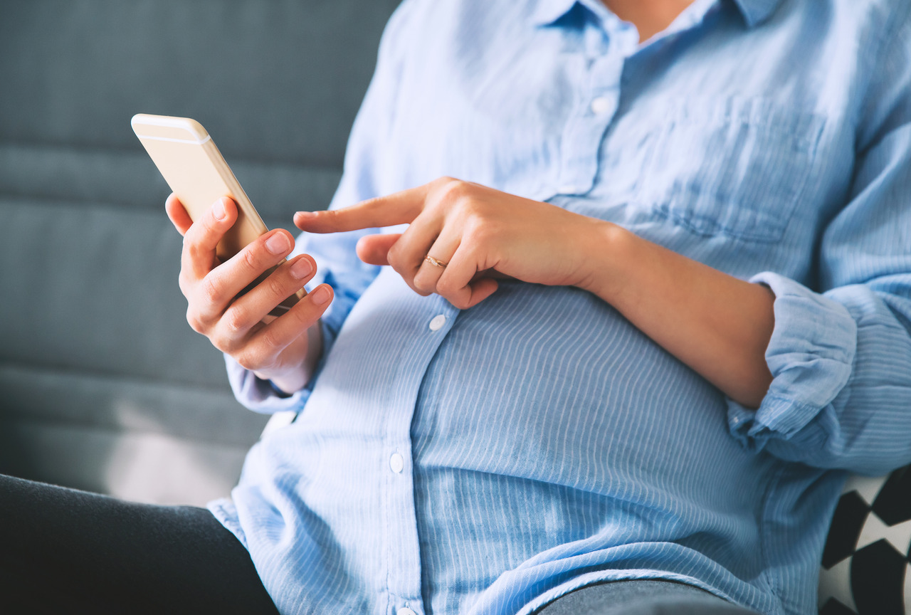 pregnant woman holding and use smartphone 