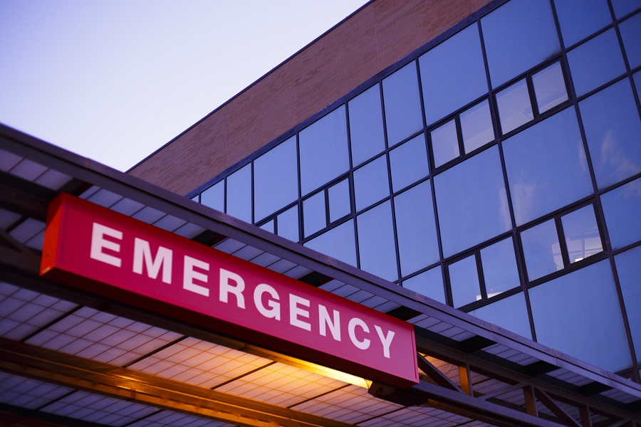A lighted emergency room sign outside of a hospital