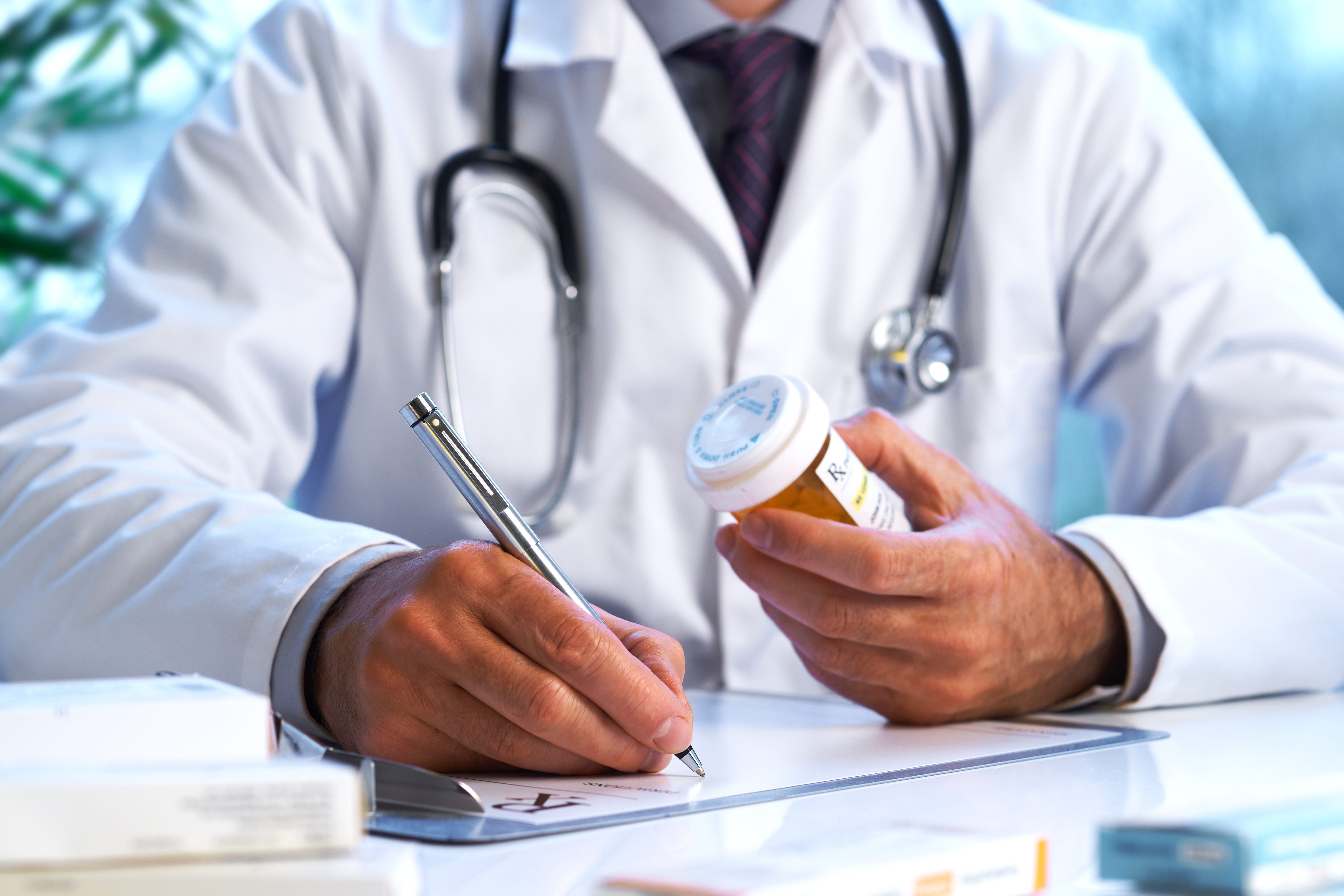 A coctor writing a prescription