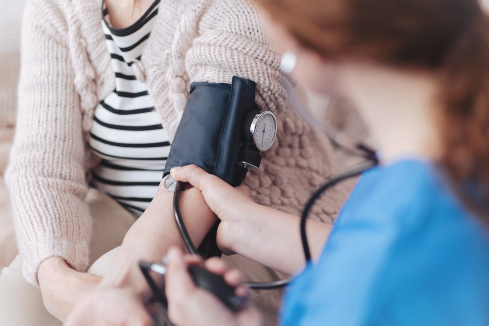 nurse taking elderly patients blood pressure
