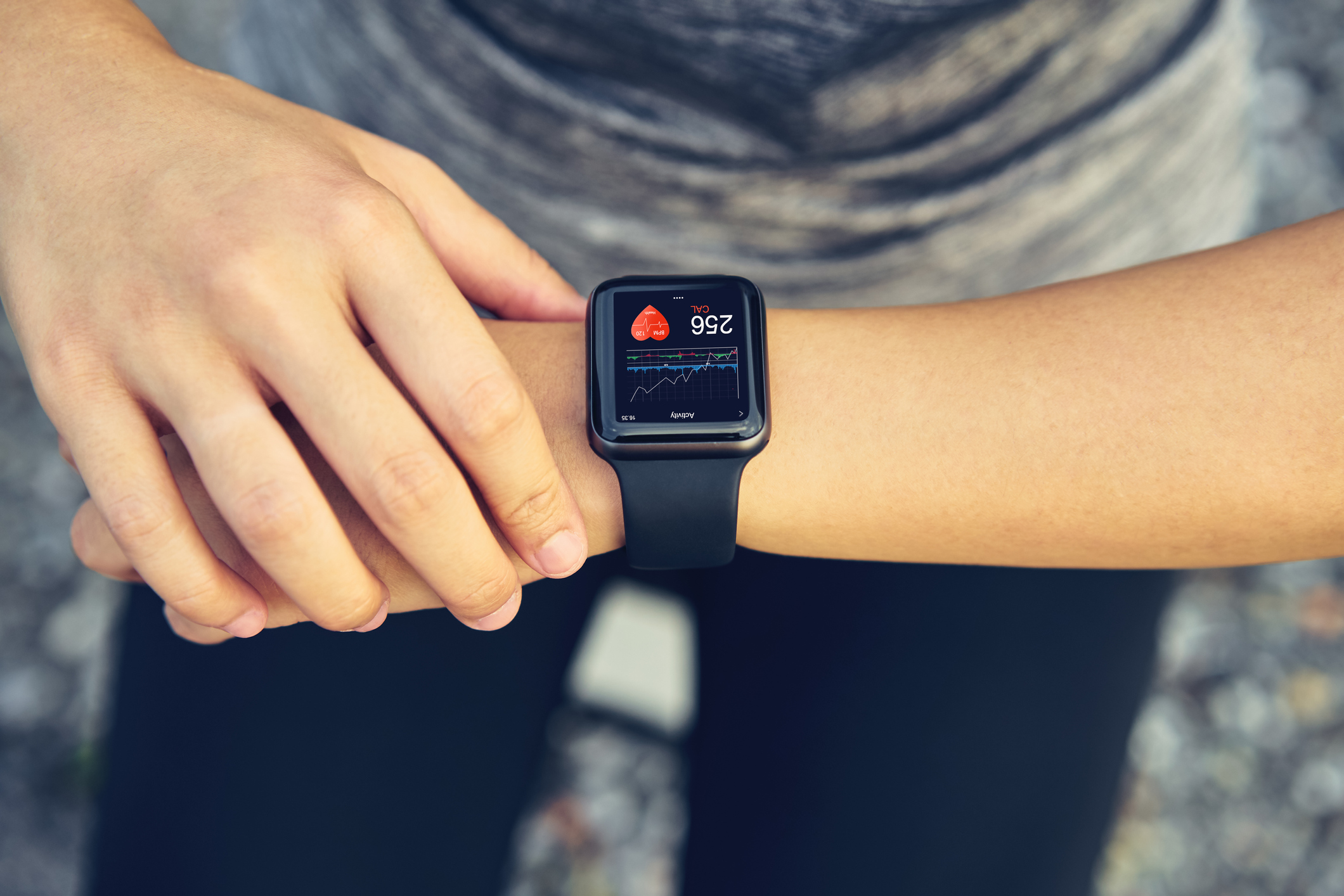 Young woman checking the sports watch measuring heart rate and performance after running