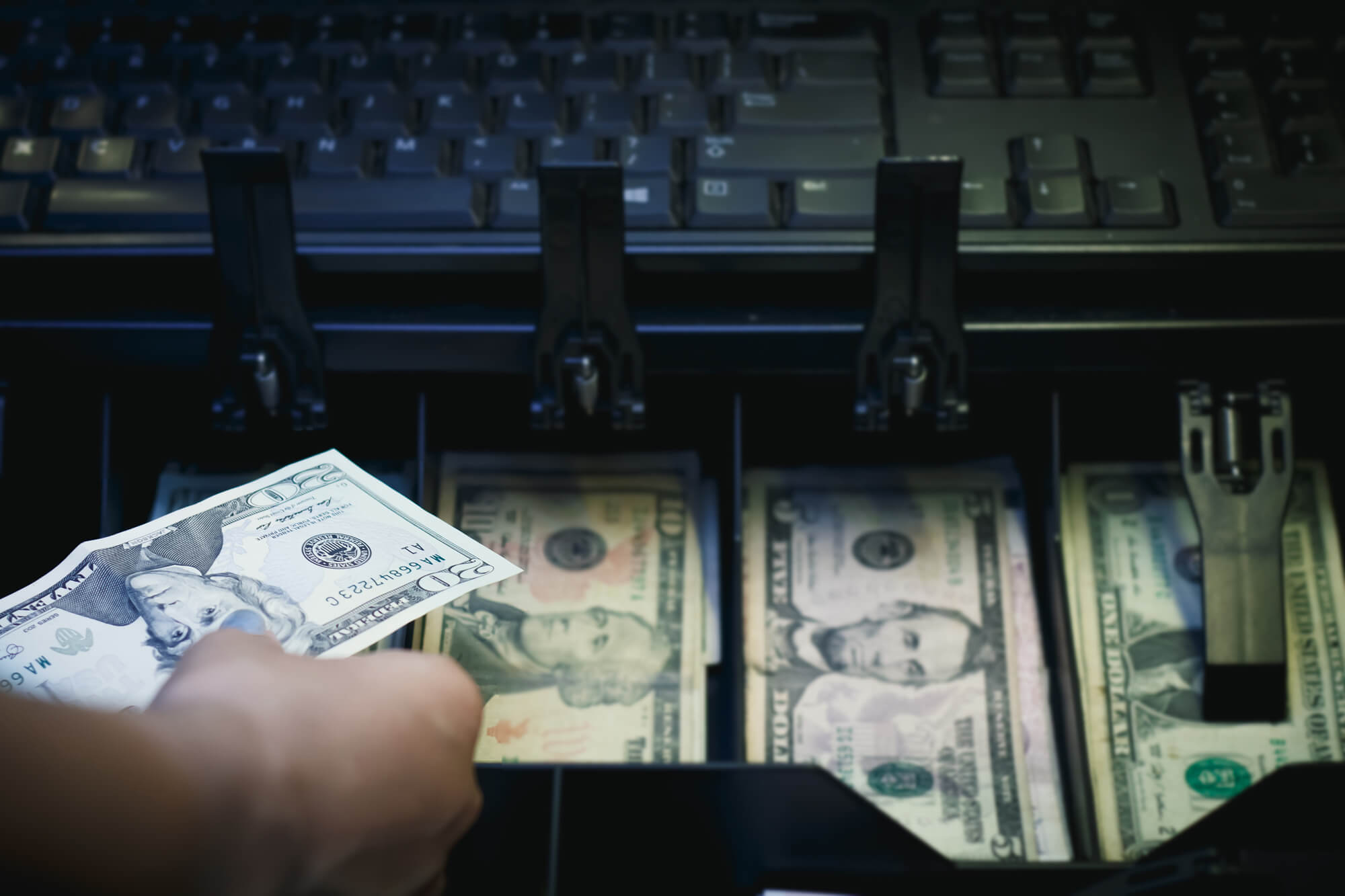 Hand reaching into or pulling out of cash register